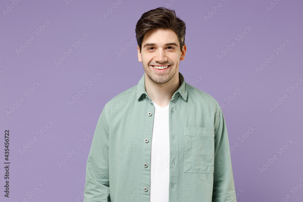 Young brunette smiling happy cheerful caucasian man 20s years old wearing casual mint shirt white t-shirt looking camera isolated on purple violet background studio portrait. People lifestyle concept Young brunette smiling happy cheerful caucasian man 20s years old wearing casual mint shirt white t-shirt looking camera isolated on purple violet background studio portrait. People lifestyle concept