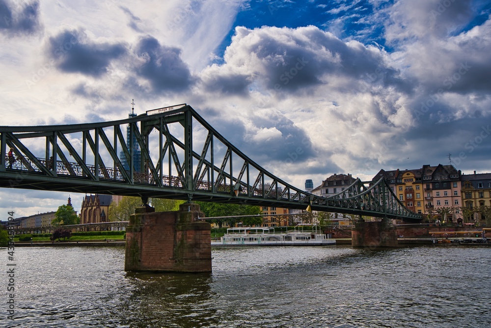 Fotografie vom eisernen Steg in Frankfurt vor einem blauen, aber sehr wolkigen Himmel. Fotografie vom eisernen Steg in Frankfurt vor einem blauen, aber sehr wolkigen Himmel.