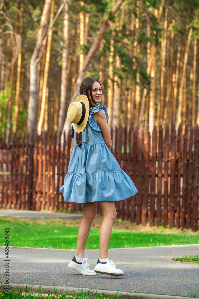 Brunette woman in a turquoise summer dress