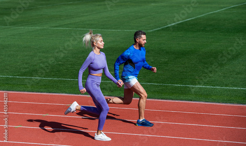 sport couple team in sportswear running on stadium, competition
