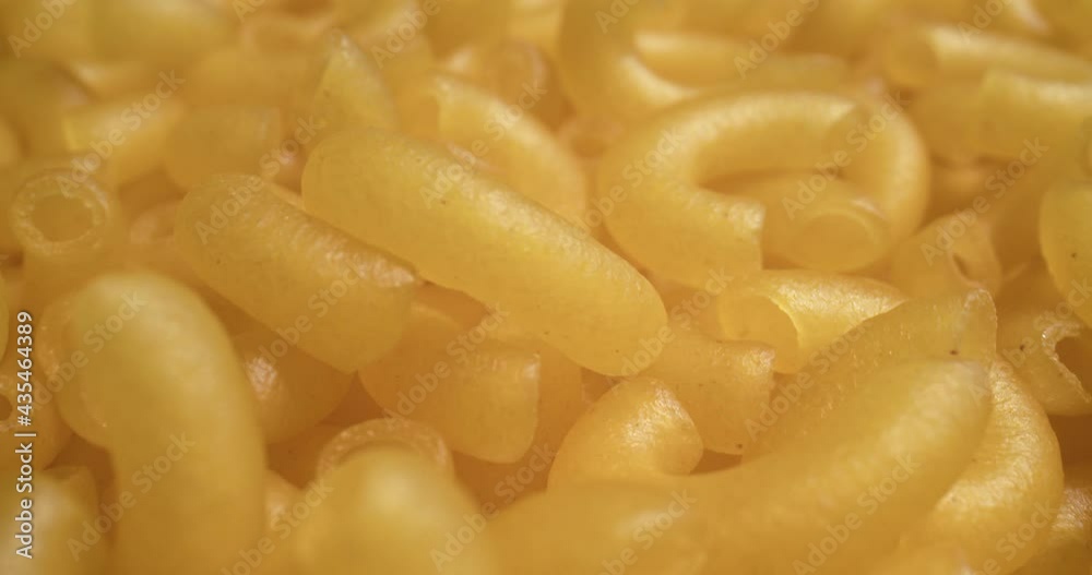 Macro probe shot of dried macaroni pasta. Shot in 4K on a cinema camera. Macro probe shot of dried macaroni pasta. Shot in 4K on a cinema camera.