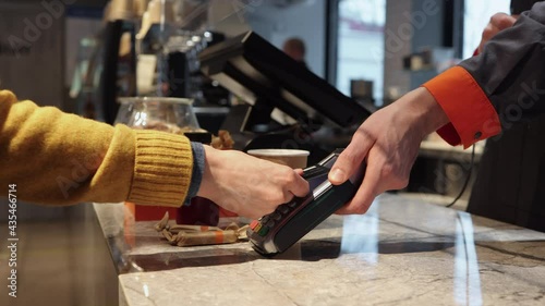 Client pay with credit card on pos terminal at cafe counter Spbi. Wireless purchase and finance