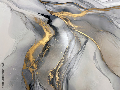 Abstract grey art with gold — black and whited background with beautiful smudges and stains made with alcohol ink and golden pigment. Gray fluid art texture resembles marble, watercolor or aquarelle. © Luvricon