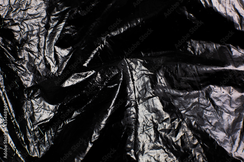 Crumpled Black Plastic Bag texture background. Glossy polyethylene overlay Crumpled Black Plastic Bag texture background. Glossy polyethylene overlay