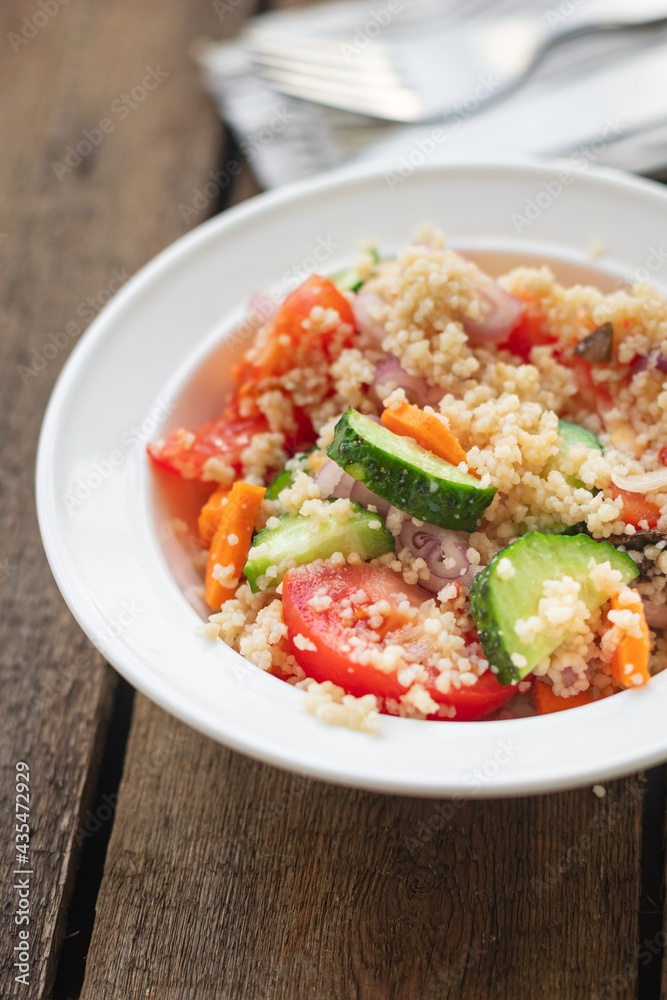 couscous salad tomato, onion, cucumber, spices vegetables appetizer fresh portion organic on the table healthy food meal snack copy space food background rustic. top view keto or paleo diet