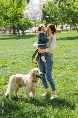 mother holding in arms disabled child with autism near golden retriever in park © LIGHTFIELD STUDIOS
