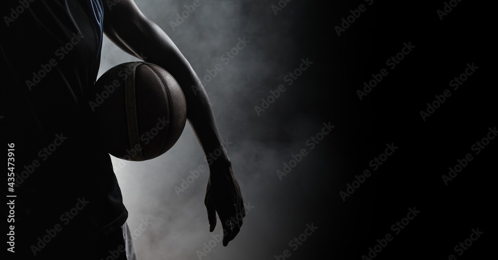 Obraz premium Composition of athletic male basketball player over smoke on black background
