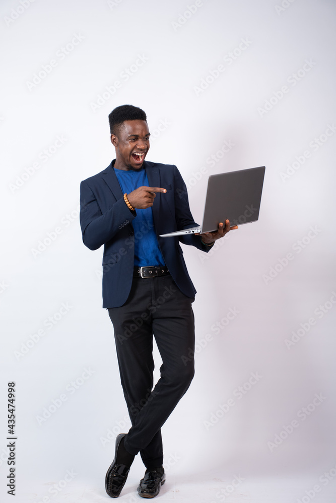 young black businessman feeling excited and happy pointing to his laptop young black businessman feeling excited and happy pointing to his laptop