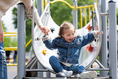 Schilderij op canvas woman holding hand of excited autistic daughter on playground