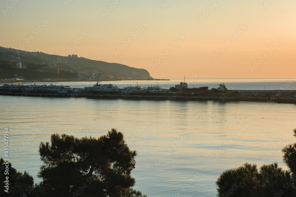 Yalta harbor in a warm light of sunrise, Crimea Yalta harbor in a warm light of sunrise, Crimea