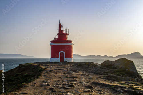 Old red lighthouse in Punta Robaleira and Islas Cies from Cabo Home, Galicia, Spain photo