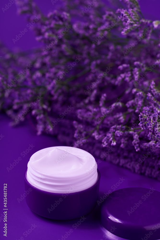 Natural night face cream or lotion, organic cosmetic to moisturize the skin with towel and flowers in the background. Natural night face cream or lotion, organic cosmetic to moisturize the skin with towel and flowers in the background.
