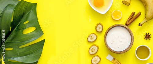Homemade skincare face banana mask banner. Homemade natural wellness cosmetics with banana pulp, yolk, honey, oatmeal, copy space, flat lay