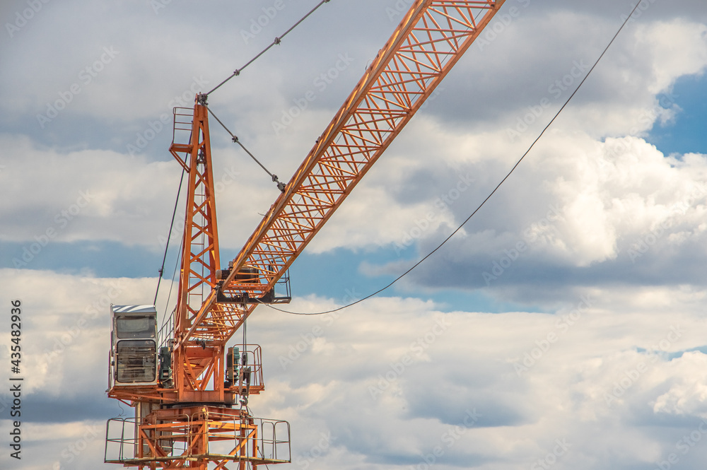 crane on a construction site against cloudy sky crane on a construction site against cloudy sky