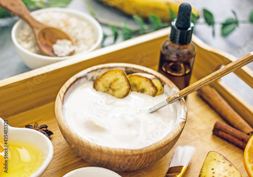Homemade cosmetic cream with banana from natural ingredients. Banana face mask at home for wellness skin and body care. Diy natural cosmetics concept background