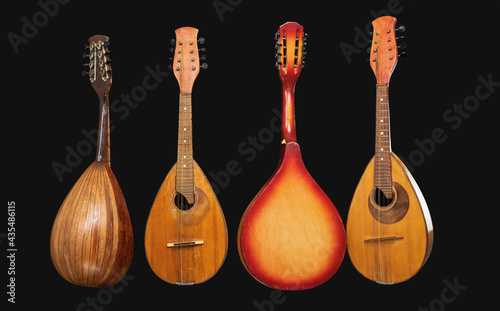 Four different old mandolins isolated on black background.