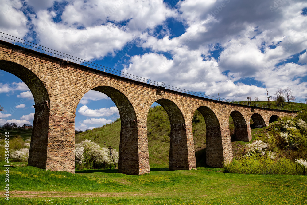 Old railway stone viaduct in the spring in sunny day.
