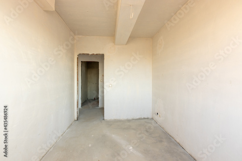 New empty room under construction. Plaster walls. New home. Concrete walls. Interior renovation.