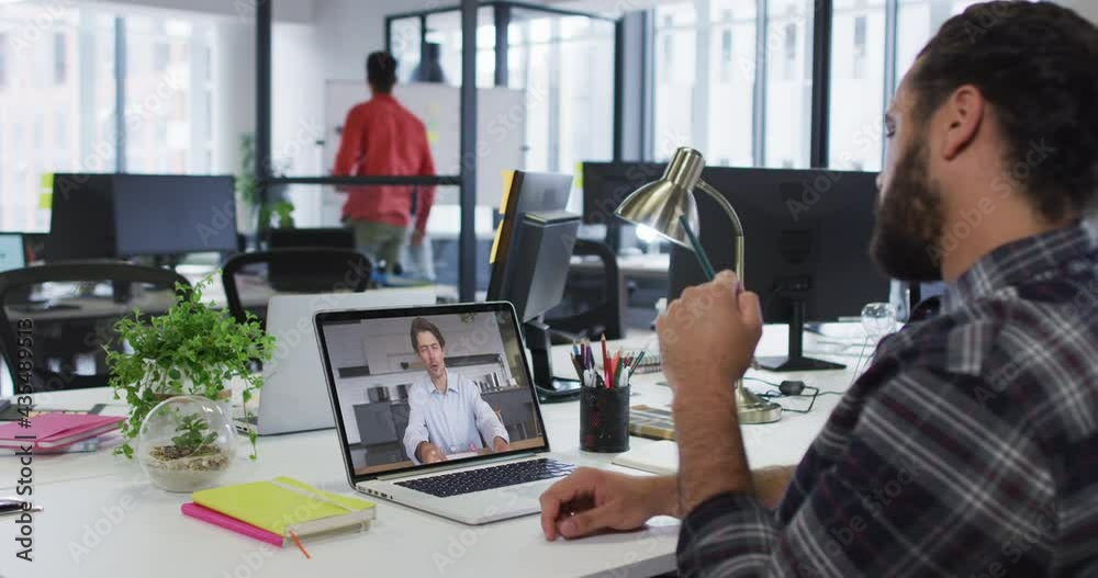 Mixed race businessman sitting at desk using laptop having video call with male colleague Mixed race businessman sitting at desk using laptop having video call with male colleague