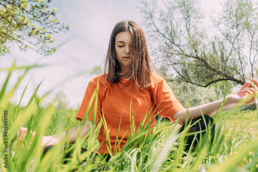 Girl in one of yoga poses outdoors on the grass Girl in one of yoga poses outdoors on the grass