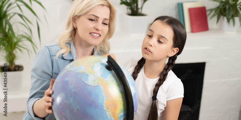 Portrait of thoughtful mother and daughter sitting at table with globe Portrait of thoughtful mother and daughter sitting at table with globe