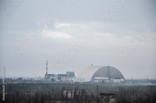 View to sarcophagus (new shelter) of reactor 4 nuclear power plant and Pripyat ghost town at Chernobyl Exclusion Zone, Ukraine 