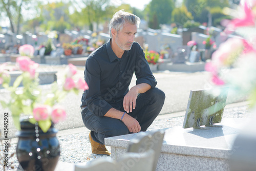 portrait of man man mourning at grave photo