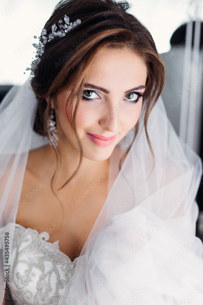Portrait of a young beautiful woman wearing a white wedding dress. Pretty slender bride with natural makeup and wavy hair. Portrait of a young beautiful woman wearing a white wedding dress. Pretty slender bride with natural makeup and wavy hair.