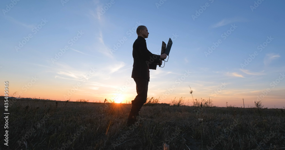 Silhouette of young male kung fu fighter practising alone in the fields during sunset Silhouette of young male kung fu fighter practising alone in the fields during sunset