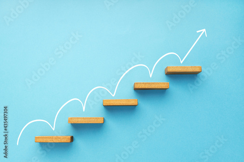 Rising arrow on staircase on blue background. Growth, increasing business, success process concept