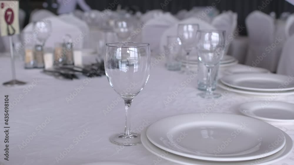 Waiter serves banquet table with blue gloves. Spoons, forks, glasses and knives. Coronavirus quarantine COVID-19 virus flu epidemic. Service staff in restaurant. close up. Banquet service Waiter serves banquet table with blue gloves. Spoons, forks, glasses and knives. Coronavirus quarantine COVID-19 virus flu epidemic. Service staff in restaurant. close up. Banquet service