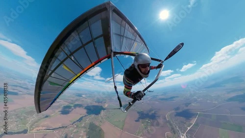 Bright rainbow colored hang glider soars on high altitude photo