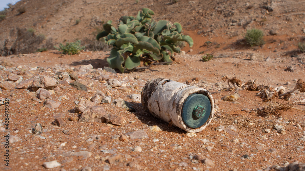 Remains of a single use rusted battery which was littered and is now polluting a desert