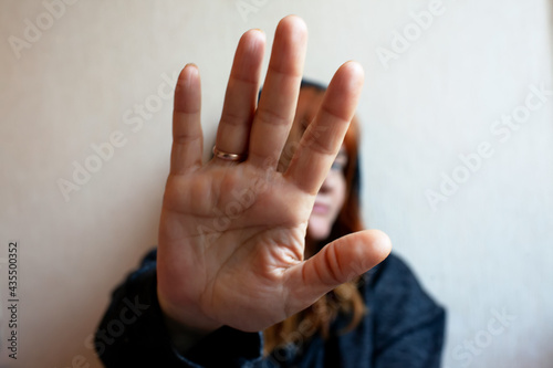 Young woman trying to defend herself with her hand
