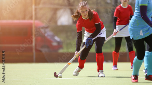 Teenage field hockey player in attack with ball