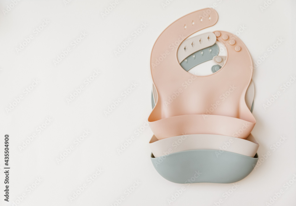 Fototapeta premium Silicone baby bib with on neutral background. Top view, flat lay
