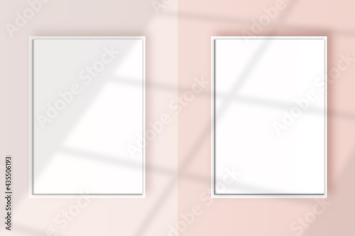 Image of a two vertical white frame mockup on a light pink wall blank mockup template.