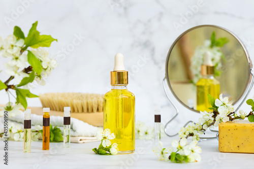 bathroom accessories, natural cosmetic product, serum, massage, aroma, essential oil in glass bottle with pipette on marble background. brush for dry massage, scrub, skin renewal and care. 