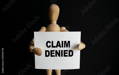 Wallpaper Mural The wooden man holds a white sign with the text CLAIM DENIED in his hands. The content of the lettering has implications for business concept and marketing. Torontodigital.ca