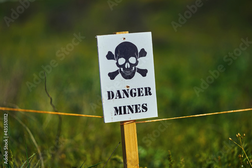 Εκτύπωση καμβά Close-up of a sign with a skull warning of danger in a minefield