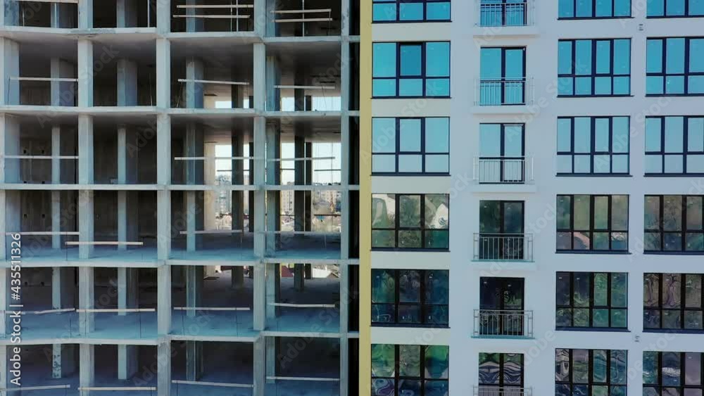 Aerial view of high residential apartment building under construction. Many windows on new apartment building facade under construction. Real estate development Aerial view of high residential apartment building under construction. Many windows on new apartment building facade under construction. Real estate development