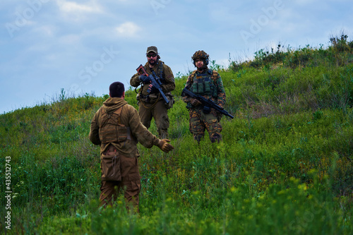 Armed military opponents negotiate on a hillside