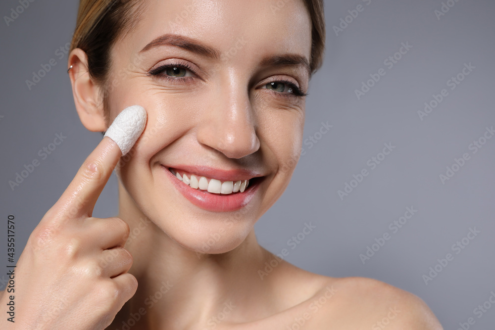 Woman using silkworm cocoon in skin care routine on grey background, closeup. Space for text Woman using silkworm cocoon in skin care routine on grey background, closeup. Space for text