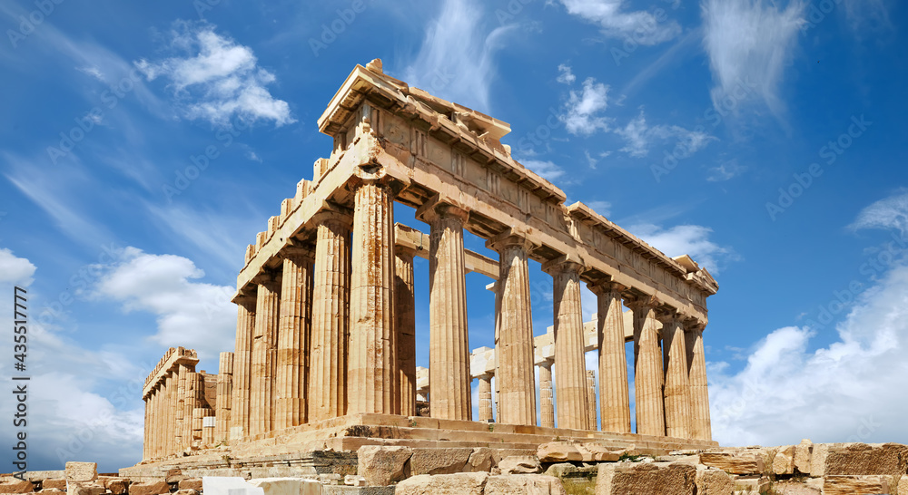 Acropolis, ancient Greek fortress in Athens, Greece. Panoramic image of Parthenon temple on a bright day with blue sky and feather clouds. Classical Greek heritage, famous place.