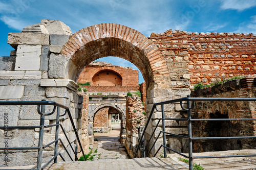 One of the entrance gate of ancient city of iznik (nicaea) made of red bricks stones city walls and stairs by taken photo during sunny day and ancient architecture arch and sky low angle photo.
