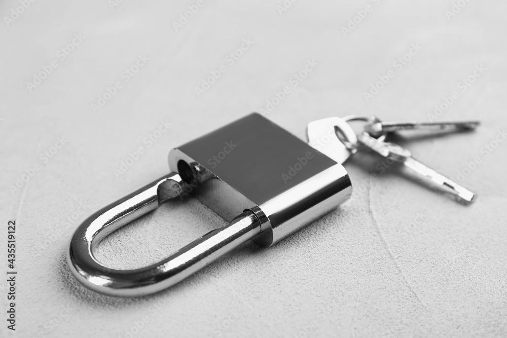 Modern padlock with keys on light table, closeup Modern padlock with keys on light table, closeup