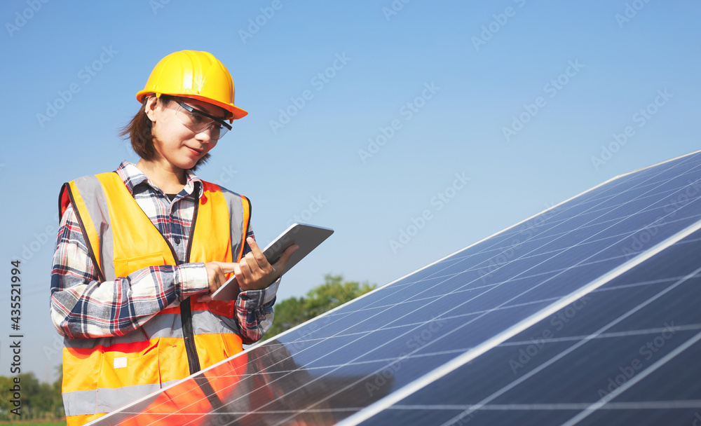 Electrical engineer holding a tablet outdoors in the Solar panel installation area. Electrical engineer holding a tablet outdoors in the Solar panel installation area.