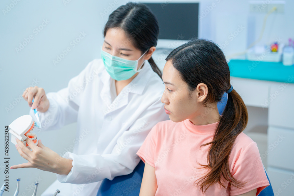 Asian orthodontist teaching orthodontics patient for tooth brushing. Asian orthodontist teaching orthodontics patient for tooth brushing.