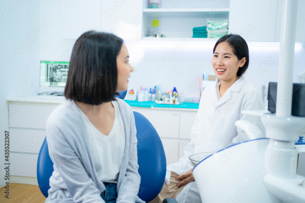 Fototapeta premium Asian female dentist giving an advice for oral treatment to patient.