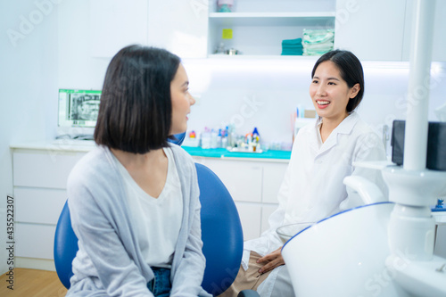 Asian female dentist giving an advice for oral treatment to patient.
